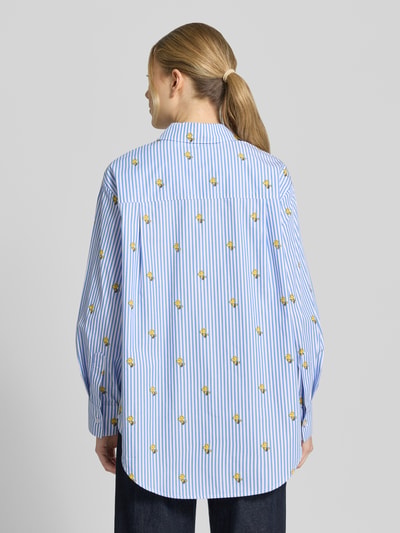 Modelka kobieca ma na sobie Oversized Hemdbluse aus reiner Baumwolle Modell 'JEPPERMINT SNOOPY' od Essentiel Antwerp, w niebiesko-białe paski z nadrukiem motywu, tkanina popelinowa, długi rękaw, widok całej sylwetki z tyłu.