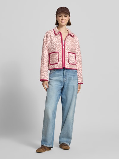Frauenmodel trägt Jacke mit Eingrifftaschen und Logo-Stitching von OH APRIL in Rosa mit roten Nähten, Regular-Fit, Umlegekragen, Reißverschluss, Denim-Jeans und braunen Schuhen, Ganzkörperansicht von vorne. Rückenlänge bei Größe S: 52 cm, Schulterbreite: 59 cm, Brustweite: 61 cm, Ärmellänge: 58 cm.