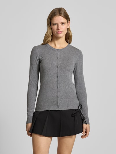 Frauenmodel trägt Slim Fit Strickjacke aus Viskose-Mix Modell 'NORA' von Pieces, Optik: Unifarben, grau, gerippte Abschlüsse, Knopf-Reißverschluss, Crew Neck, Strickstruktur, Ganzkörperansicht von vorne.