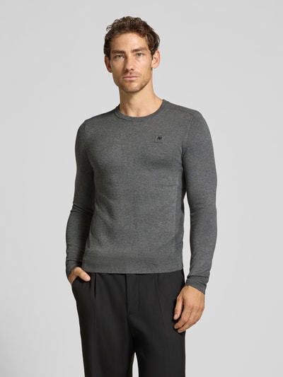 Männermodel trägt Regular Fit Sweatshirt aus elastischem Viskose-Mix von Antony Morato, dunkelgrau, Label-Detail, elastische Abschlüsse, Ganzkörperansicht von vorne.