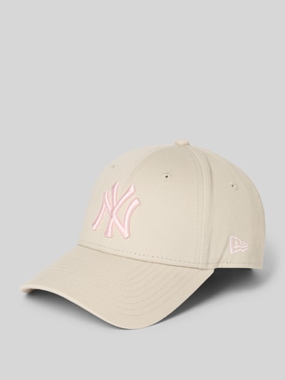 Produktfoto, Base Cap mit Motiv-Stitching von New Era aus reiner Baumwolle in Beige mit rosa Logo-Stitching und gebogenem Schirm auf grauem Hintergrund.