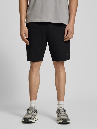 Männermodel trägt Straight Fit Shorts mit Strukturmuster von G-Star Raw, Elastischer-Material-Mix mit Baumwoll-Anteil, Logo-Detail, Ganzkörperansicht von vorne.