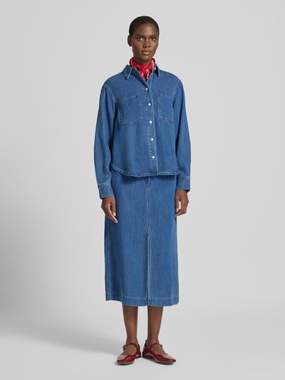 Frauenmodel trägt Jeansrock mit Knopf- und Reißverschluss Modell 'SATOVES' von Samsøe Samsøe, reine Lyocell, A-Linie, Midirock, mittelblau, Ganzkörperansicht von vorne.