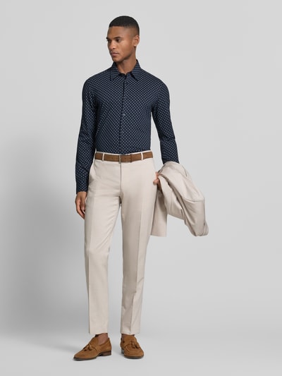 Männermodel trägt Slim Fit Businesshemd aus Baumwoll-Mix Modell 'P-ROAN-K-F-261' von BOSS, Optik: Allover-Muster, Ganzkörperansicht von vorne.