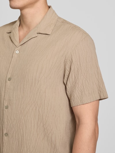 Männermodel trägt Regular Fit Freizeithemd mit Reverskragen von Jack & Jones Premium, beige, strukturierte Baumwoll-Elasthan-Mischung, Nahaufnahme Oberkörper.