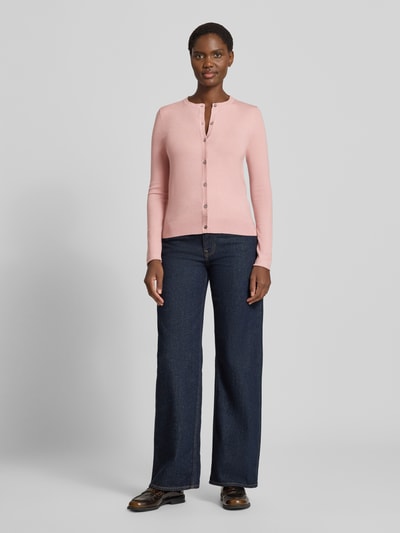 Vrouwenmodel draagt Regular Fit gebreid jack uit viscosemix met geschulpte zoom van Christian Berg Woman, lange mouw, knoopsluiting, ribboorden, ruglengte maat S 56 cm, mouwlengte maat S 61 cm, Ganzkörperansicht van voren.
