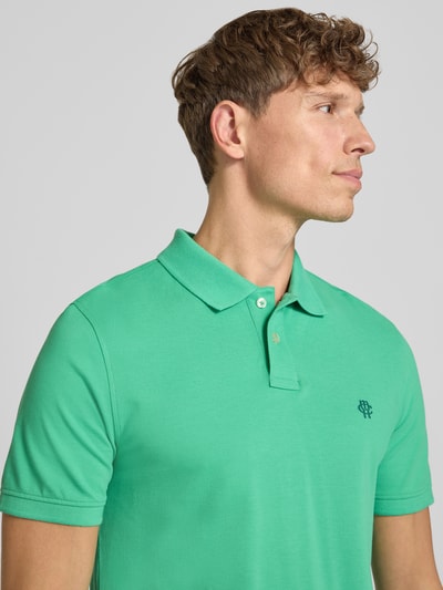Männermodel trägt Slim Fit Poloshirt mit Label-Stitching von MCNEAL aus Reiner Baumwolle, Knopfleiste, Rückenlänge 72 cm, Nahaufnahme Oberkörper.