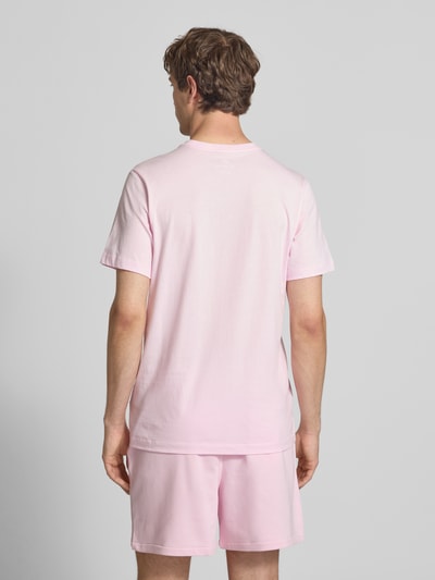 Mannelijk model draagt T-shirt met Label-Stitching van Nike in lichtroze, puur katoen, regular fit, ronde hals, ruglengte maat M 73 cm. Ganzkörperansicht Rückansicht.