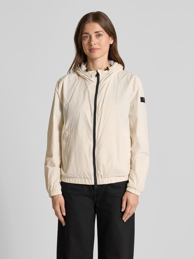 Frauenmodel trägt Regular Fit Jacke mit Kapuze Modell 'Nigle' von Peuterey in Beige mit Eingrifftaschen, elastische Abschlüsse, Zweiwege-Reißverschluss, Ganzkörperansicht von vorne. Rückenlänge bei Größe 38: 60 cm, Schulterbreite: 47 cm, Brustweite: 57 cm, Ärmellänge: 61 cm.