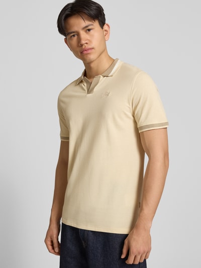 Männermodel trägt Regular Fit Poloshirt mit Label-Stitching Modell 'EVO' von Blend aus Reine Baumwolle in Beige, Nahaufnahme Oberkörper. Rückenlänge bei Größe M: 72 cm.