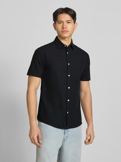 Männermodel trägt Regular Fit Freizeithemd aus Baumwoll-Leinen-Mix von Jack & Jones in Schwarz, weiße Knopfleiste, Kentkragen, Ganzkörperansicht von vorne. Rückenlänge 76 cm, Schulterbreite 50 cm, Ärmellänge 26 cm, Modell BREEZE.