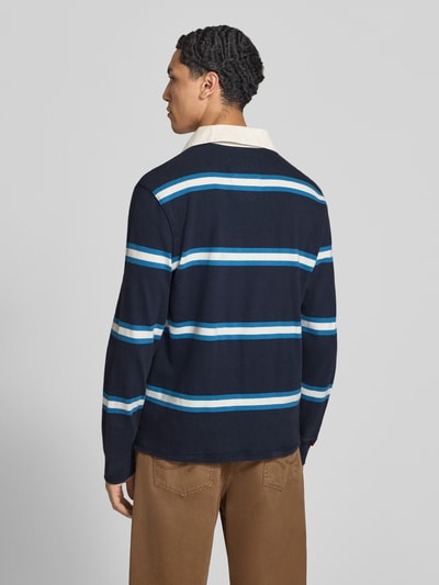 Männermodel trägt Poloshirt aus reiner Baumwolle von Superdry, dunkelblau mit weißen und hellblauen Streifen, gerader Schnitt, Rückenansicht, KI-modifiziertes Bild.
