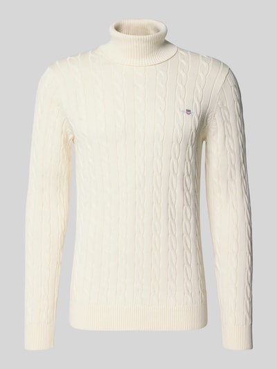 Produktfoto, Rollkragenpullover mit Logo-Detail von GANT aus reiner Baumwolle, cremefarben mit Zopfmuster, gerippte Abschlüsse, langarm