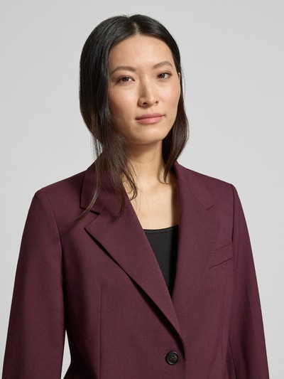 Vrouwenmodel draagt Relaxed Fit Kurzblazer aus Wollmix van Tommy Hilfiger in effen bordeaux, 2-knoopsluiting, relaxed fit, close-up bovenlichaam.