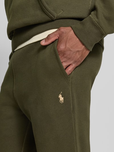 Mannenmodel draagt Relaxed Fit Sweathose uit katoenmix van Polo Ralph Lauren in olijfgroen, zachte textuur, detailopname. Heren Sweathose