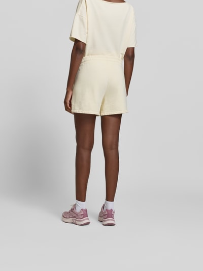 Frauenmodel trägt Shorts mit Modal-Anteil von Juvia in Creme, Baumwoll-Mix, Eingrifftaschen, elastischer Bund, Regular-Fit, Ganzkörperansicht Rückansicht.