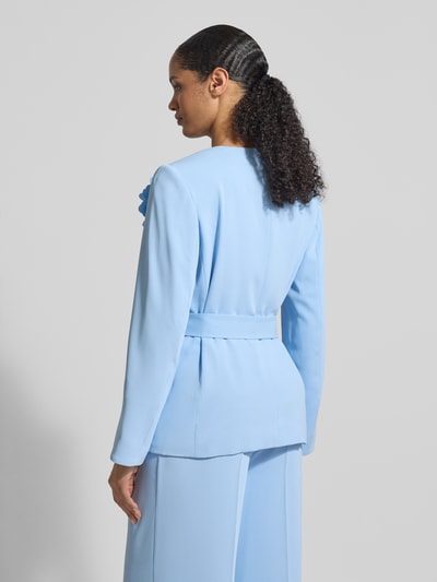 Vrouwenmodel draagt Blazer mit Taillengürtel van Christian Berg Cocktail in lichtblauw met getailleerde pasvorm en sierapplicatie, afneembare tailleriem, ruglengte maat 36: 68 cm, geheellichaamsaanzicht achteraan.