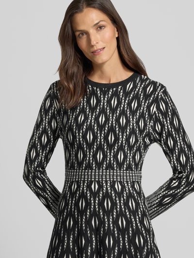 Vrouwenmodel draagt Knielanges Strickkleid im Allover-Look van Apricot in zwart-wit met all-over look, Viscosemix, A-lijn, knielengte, ronde hals, ruglengte maat S 103 cm, borstwijdte maat S 37 cm, mouwlengte maat S 59 cm, Nahaufnahme bovenlichaam.