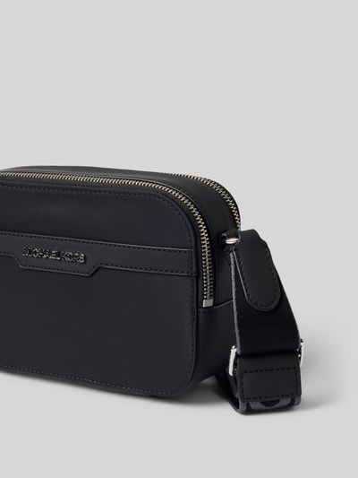 Produktfoto, schwarze Handtasche mit Schulterriemen Modell 'MALONE' von Michael Kors, Label-Detail, glatte Oberfläche, silberner Reißverschluss, rechteckige Form, Größe: 21x14x6 cm, Länge Schulterriemen: 104 cm