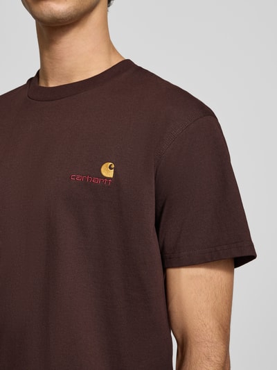 Männermodel trägt T-Shirt mit Label-Stitching van Carhartt Work In Progress, katoen, regular fit, geribbelde ronde hals, detailopname bovenlichaam.