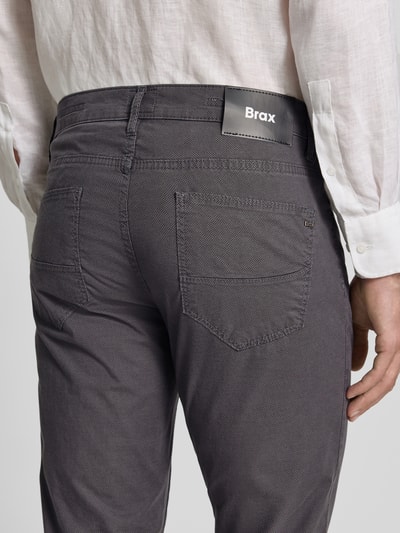Männermodel trägt Regular Fit Hose mit 5-Pocket-Design aus Baumwoll-Mix Modell 'Cadiz' von Brax, Optik: Unifarben, Detailaufnahme Rückansicht.