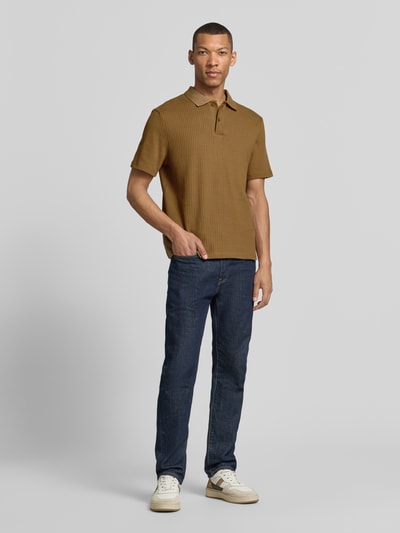 Männermodel trägt Modern Fit Polokragen mit kurzer Knopfleiste Modell 'JASE' von Samsøe Samsøe aus reiner Baumwolle, Strukturmuster, Ganzkörperansicht von vorne.