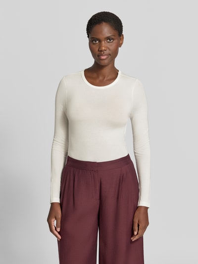Frauenmodel trägt Slim Fit Langarmshirt aus Lyocell-Mix Modell 'ADA' von VERO MODA in Creme zu bordeauxroter Hose, Ganzkörperansicht von vorne. Damen Langarmshirt von VERO MODA