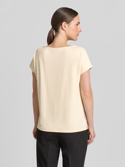 Frauenmodel trägt Relaxed Fit T-Shirt mit Allover-Muster von s.Oliver BLACK LABEL, Optik:Allover-Muster, Passform: Relaxed-Fit, U-Boot-Ausschnitt, Ärmelform: Kurzarm, sanfte Cremefarbe, glatte Textur, Ganzkörperansicht Rückansicht.