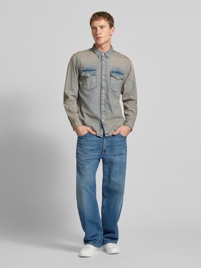 Männermodel trägt Relaxed Fit Jeanshemd mit Brusttaschen Modell 'WESTERN' von Levi's®, puur katoen, knoopsluiting, kentkraag, labeldetail, afgeronde zoom, sportmanchet, grijze denim look, Heren, Ganzkörperansicht von vorne.