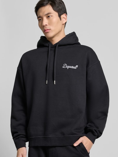 Männermodel trägt Regular Fit Hoodie mit Logo-Stitching von Dsquared2 in Schwarz, reine Baumwolle, Nahaufnahme Oberkörper.