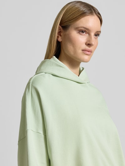 Frauenmodel trägt Relaxed Fit Hoodie aus reiner Baumwolle von Marc O'Polo, Optik: Unifarben, Passform: Relaxed-Fit, Label-Print, Materialverarbeitung: Sweat, Kapuze, Langarm, überschnittene Schultern, Gerippt an Ärmelabschluss und Rumpfabschluss, Nahaufnahme Oberkörper.