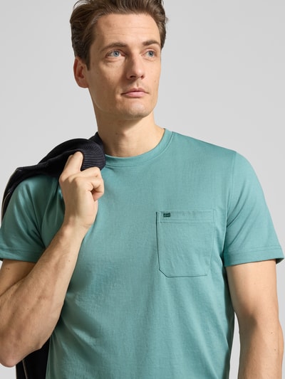 Männermodel trägt T-Shirt mit Rundhalsausschnitt und Brusttasche von Christian Berg Men, Material-Mix, Regular Fit, Nahaufnahme Oberkörper.
