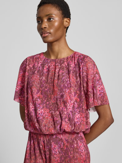 Frauenmodel trägt Regular Fit Bluse in Falten-Optik von Rich & Royal mit floralem Print, kurzärmelig, elastischer Bund, Nahaufnahme Oberkörper.