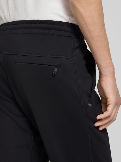 Männermodel trägt Regular Fit Sweatpants aus schnell trocknenden Material Modell 'HICON ACTIVE' von BOSS Green, Optik: Unifarben, Passform: Regular-Fit, Applikation: Label-Print, Bundabschluss: elastisch, Flatlock-Innennähte, seitliche Eingrifftaschen, Gesäßtasche, Nahaufnahme Rückansicht.