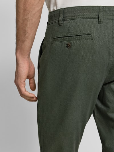 Männermodel trägt Stoffhose mit französischen Eingrifftaschen von MCNEAL, Baumwoll-Elasthan-Mix, dunkelgrün, Gesäßtaschen, Detailaufnahme Rückansicht.