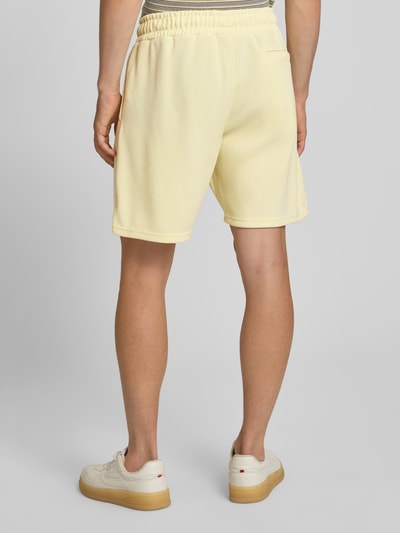 Männermodel trägt Relaxed Fit Shorts mit Strukturmuster Modell 'Lagos' von Pegador in Hellgelb, elastischer Bund, Rückansicht, Detailaufnahme, Herren Shorts, Material-Mix, Größe M 38 cm Bundweite, 21 cm Innenbeinlänge.