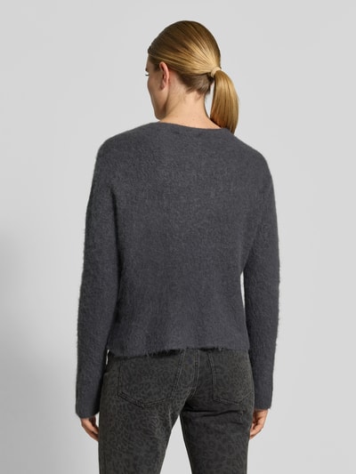 Vrouwenmodel draagt Wollpullover aus Alpaka-Woll-Mix van Juvia in donkergrijs met tricotlook, los model, ruglengte 57 cm, borstwijdte 50 cm, mouwlengte 62 cm, mix van alpaca en wol, ronde hals, schouderpartijen overlopend, rugaanzicht