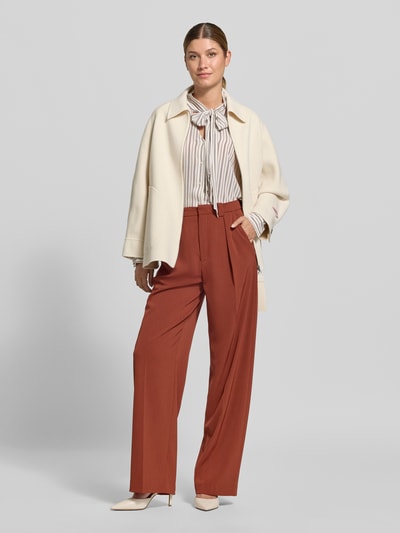 Frauenmodel trägt Relaxed Fit Kurzmantel aus reiner Schurwolle Modell 'MCOSAGGINA' von MAX&Co., unifarben, mit Umlegekragen, Reißverschluss, aufgesetzten Taschen, grobe Wolltextur, Ganzkörperansicht von vorne.