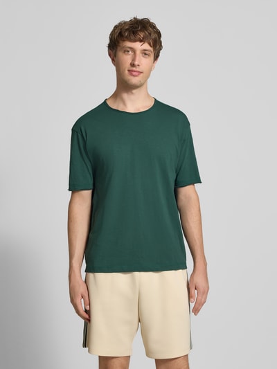 Männermodel trägt Relaxed Fit T-Shirt aus reiner Baumwolle von Marc O'Polo Denim in Optik: Unifarben, Passform: Relaxed-Fit, Rundhals, Ärmelform: Kurzarm, Raw Cut Saum, Material: Reine Baumwolle, Ganzkörperansicht von vorne.