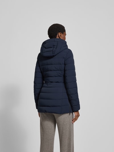 Frauenmodel trägt Daunenjacke mit Kapuze von Moose Knuckles in Dunkelblau, Material-Mix mit Stretch-Anteil, taillierter Schnitt, Reißverschluss, Reißverschlusstaschen, Rückenlänge 75 cm, Brustweite 48 cm, Ärmellänge 65 cm, Ganzkörperansicht Rückansicht.