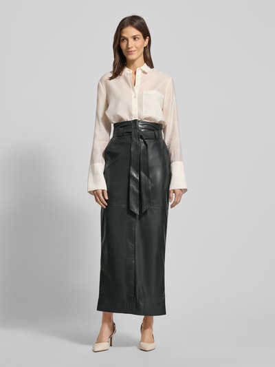Frauenmodel trägt Eng anliegender Midi-Rock mit seitlichen Eingrifftaschen Modell 'VACARO' von BOSS Orange, Optik: Unifarben, Passform: eng anliegend, Länge: Midi, Label-Stitching-Applikation, Metall-Akzente, Gürtelschlaufen, Gehschlitz, Passe, Bindegürtel, Verschluss: Knopf und verdeckter Reißverschluss, Materialverarbeitung: Kunstleder, Ganzkörperansicht von vorne.