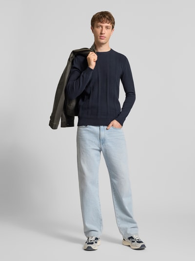 Männermodel trägt Slim Fit Pullover in Strick-Optik Modell 'Baron' von Blend in Dunkelblau aus Reine Baumwolle, Ganzkörperansicht von vorne.