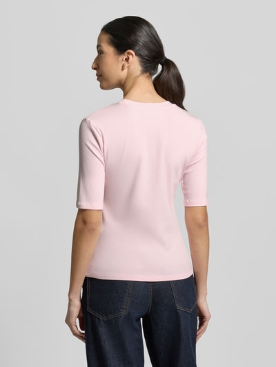 Frauenmodel trägt Slim Fit T-Shirt im Halbarm-Design von Christian Berg Woman aus elastischem Baumwoll-Mix in Rosa, Rückenlänge 54 cm, Ganzkörperansicht Rückansicht.