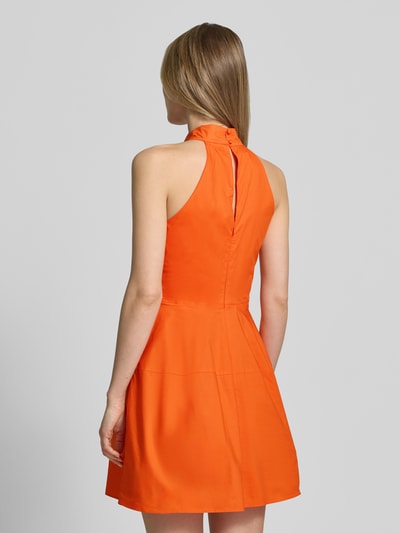 Frauenmodel trägt Cocktailkleid mit Stehkragen und rückseitigem Knopfverschluss von Little Mistress aus reiner Baumwolle in A-Linie, Minikleid, intensives Orange, glatte Textur, Rückenlänge 84 cm, Brustweite 42 cm, Ganzkörperansicht Rückansicht.