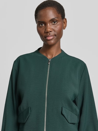 Frauenmodel trägt Jacke mit Reißverschluss und Pattentaschen von Zero in Dunkelgrün, Regular-Fit, Stehkragen, Nahaufnahme Oberkörper. Rückenlänge bei Größe 36: 46 cm, Schulterbreite: 40 cm, Brustweite: 49 cm, Ärmellänge: 60 cm, glatte Textur.
