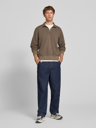 Männermodel trägt Regular Fit Sweatshirt aus reiner Baumwolle von G-Star RAW in Braun, kombiniert mit Jeans, Ganzkörperansicht von vorne.