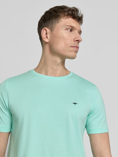 Męski model nosi T-Shirt mit Rundhalsausschnitt und Label-Stitching od Fynch-Hatton, miętowy kolor, bawełna, krój regular fit, okrągły dekolt, wyhaftowane logo, długość tyłu w rozmiarze M: 71 cm, zbliżenie na górną część ciała, widok z przodu.