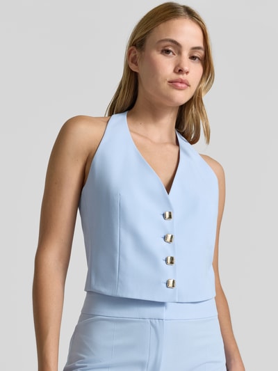 Frauenmodel trägt Regular Fit Weste mit Neckholder Modell 'ANUNA' von HUGO, einreihige Knopfleiste, unifarbener Look, Nahaufnahme Oberkörper.