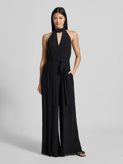 Frauenmodel trägt Regular Fit Jumpsuit aus reiner Viskose Modell 'Chiva' von Ted Baker in Schwarz mit Zierschleife, Ganzkörperansicht von vorne.