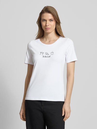 Frauenmodel trägt T-Shirt mit Motiv-Print von More & More aus Baumwoll-Elasthan-Mix in Weiß, Regular-Fit, Rundhalsausschnitt, Ganzkörperansicht von vorne.